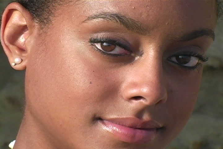 A young woman with beautiful eyes staring at the camera.  