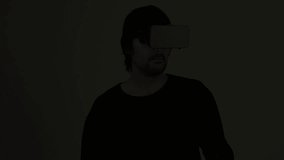 Accelerated confused male actor immersed in experience of virtual reality environment wearing vr goggles, augmented-reality headset, and enjoying 3d cyberspace multimedia content.