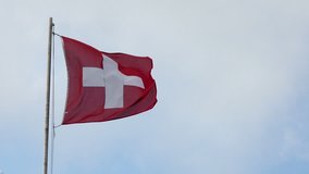 Switzerland National Flag Waving in the Wind against a Blue Sky. Full HD 1920x1080 Video Clip