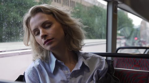 4K Blonde girl sits on a bus
