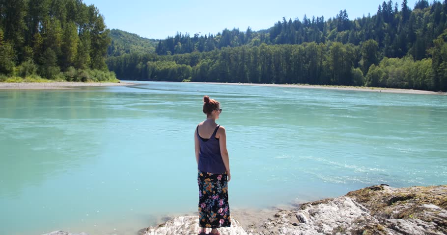 Young Woman Admiring Landscape by Lake