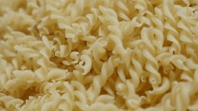Slow motion corkscrew shaped pasta pile fall on table close-up 1920X1080 HD footage -  Falling on top pieces of famous Italian food  slow-mo 1080p FullHD tilting video
