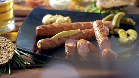Eating a tasty bratwurst dressed with mustard with a fork during a breakfast. Warm and tasty mood. Very closeup shot