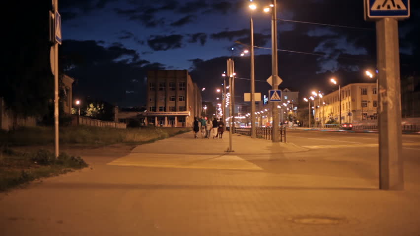 Rear view of young friends going on the city at evening