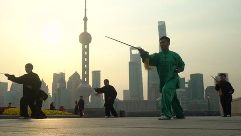 Shanghai, China - March 2016: Group exercising with Tai Chi on The Bund
