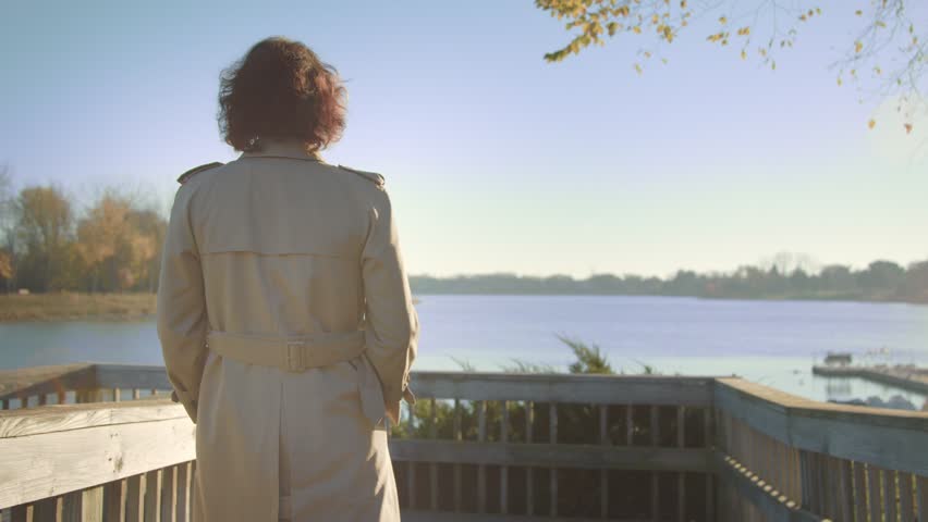 Woman goes on the bridge to the lake.