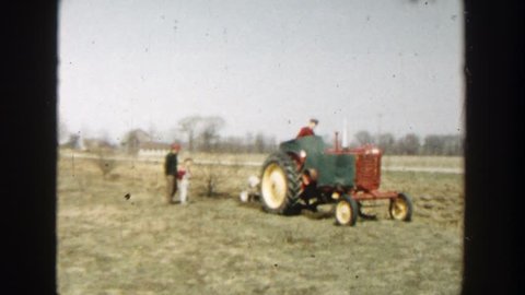 WISCONSIN DELLS WISCONSIN 1954: tractor driving through a large grass field while pulling plow