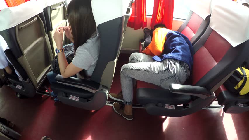 MANILA, PHILIPPINES - NOVEMBER 13, 2016: high school boy sleeping lying on seat of moving bus jolting