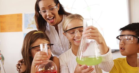 Front view of diverse school kids doing a chemical experiment in laboratory at school Adlı Stok Video