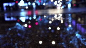 Defocus night view of holiday lights and city traffic reflecting in a rain puddle on the streets of London