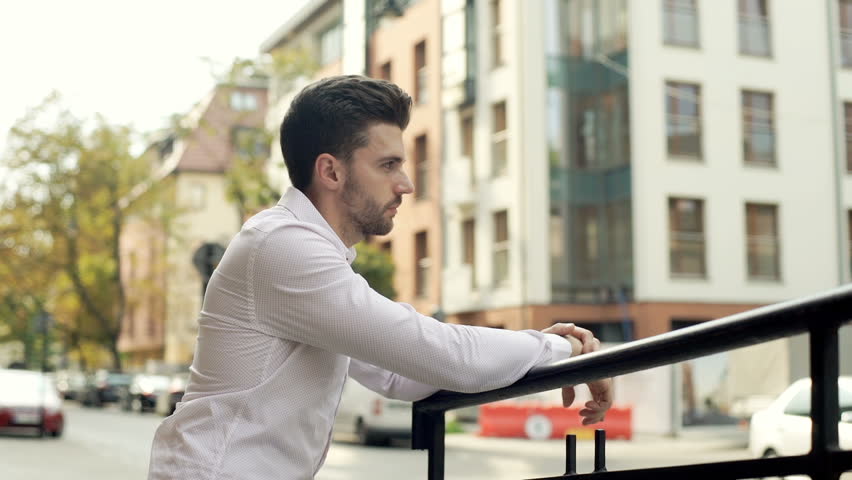 Handsome, stylish man doing serious look to the camera while leaning on barriers

