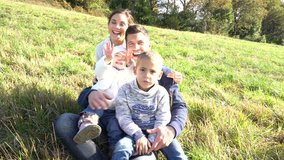 Happy family sitting in country field, autumn day