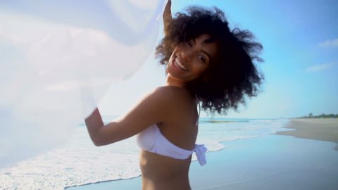 Portrait playful young African American woman lifestyle recreation enjoyment Summer vacation swimwear white scarf ocean beach