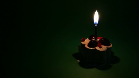 cake in dark with burning candle