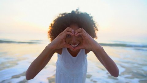 Portrait happy young attractive African American female heart sign hands love lifestyle recreation Summer vacation beach