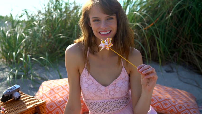 Portrait happy slim Caucasian American woman lifestyle relaxation pinwheel picnic Summer vacation ocean beach Boho Retro