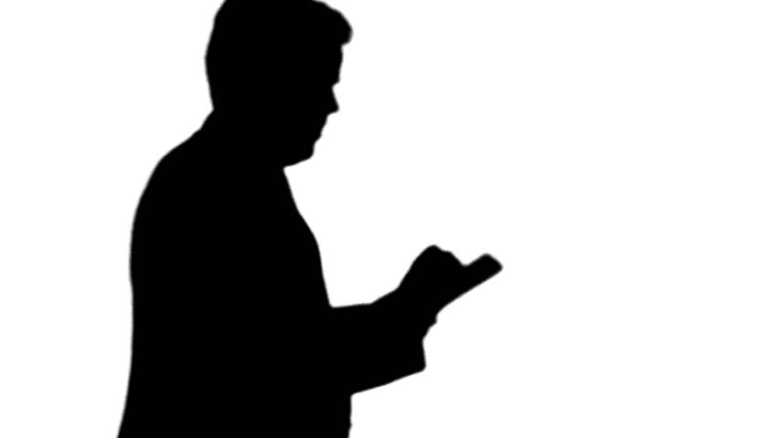 Silhouette of man working on tablet