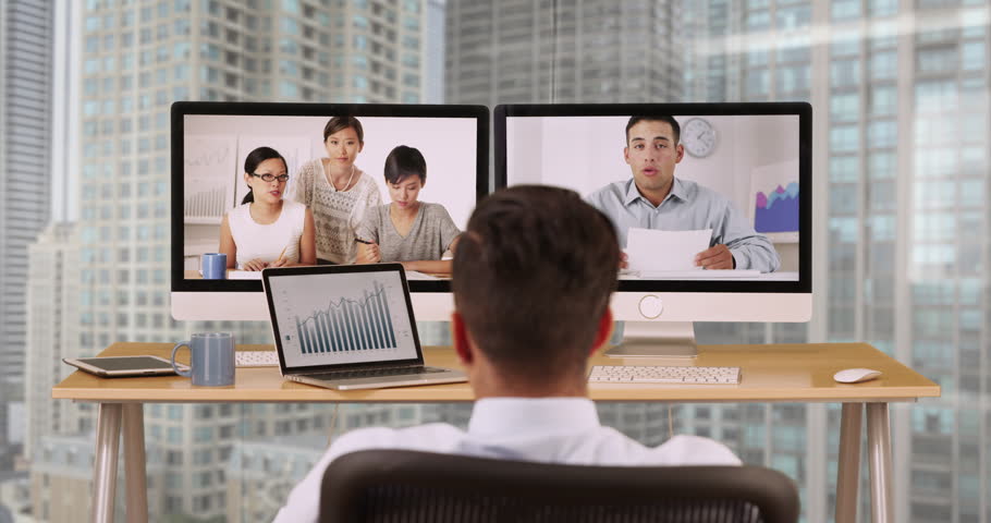 Businessman in highrise office talking to colleagues over video conference. Hispanic and Asian group of ethnically diverse group of business professional using computer for VoIP Royalty-Free Stock Footage #21542227