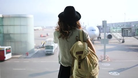 girl standing at the window in airport terminal.
