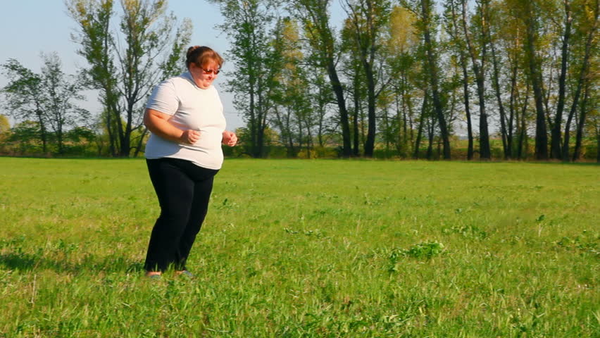 sport - overweight woman exercising on green meadow
