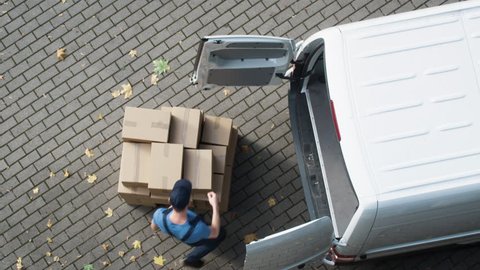 Delivery Man Loads his Commercial Van with Cardboard Boxes. Shot on RED Cinema Camera in 4K (UHD)