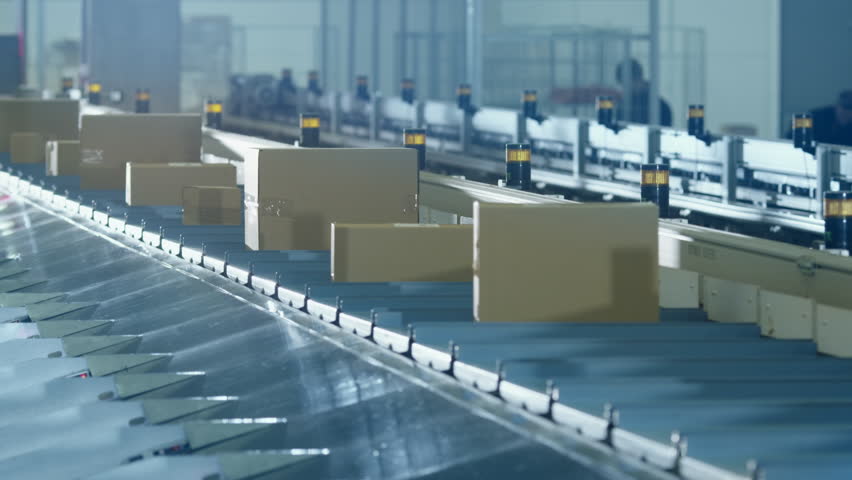 Parcels are Moving on Belt Conveyor at Post Sorting Office. Box POV. Automated Delivery Sorting Online Order Delivery Facility in Warehouse Logistics Facility Working Without People Royalty-Free Stock Footage #21557059