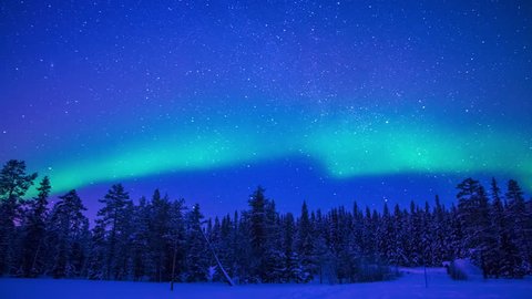 Lapland. Night. Winter forest. Starry sky and Northern Lights. Time lapse