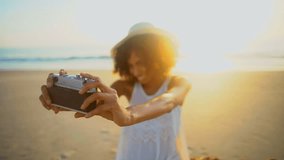 Attractive African American girl lifestyle leisure sunhat selfie camera technology Summer vacation ocean beach sunset flare