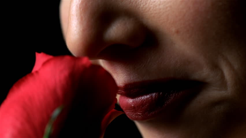 Detail of female smelling rose