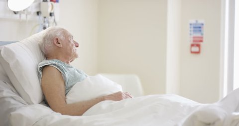 4K Caring medical worker in hospital talking to elderly man at his bedside (UK-Oct 2016)