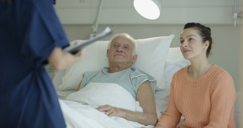 4K Daughter visiting elderly father in hospital and medical worker talking to them (UK-Oct 2016)