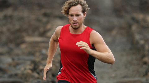 Athlete running - male runner exercising outdoors. Man triathlete running fast on lava trail living healthy active lifestyle training for marathon or triathlon outside. Big Island, Hawaii, 59.94 FPS.