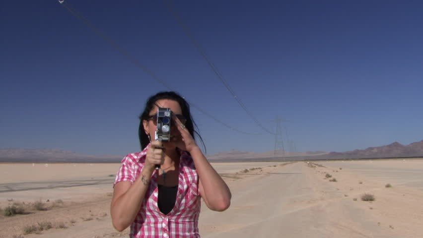 Female in desert using a cine camera