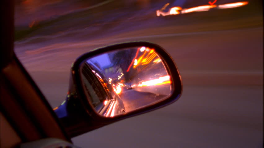 Traffic blur through side mirror of car
