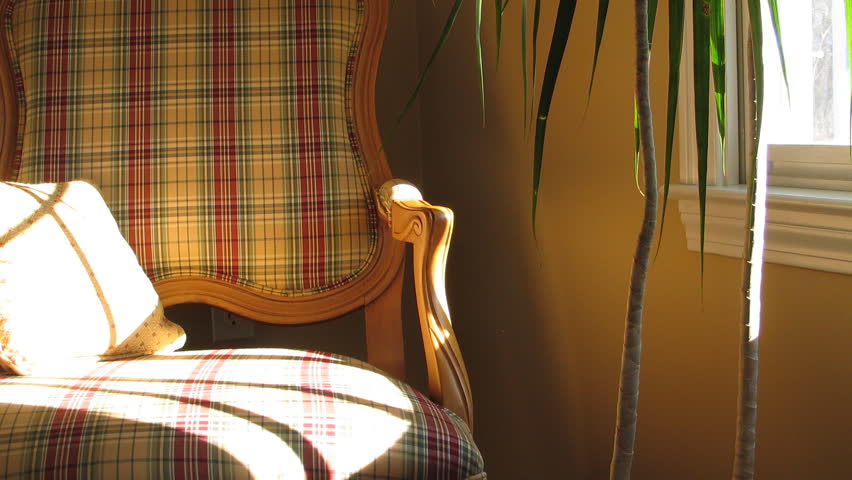 Time lapse of sunlight moving over plaid chair