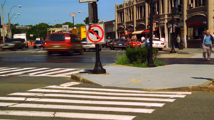 BROOKLINE, MA - CIRCA MAY 2002: Pedestrians cross a busy street corner in