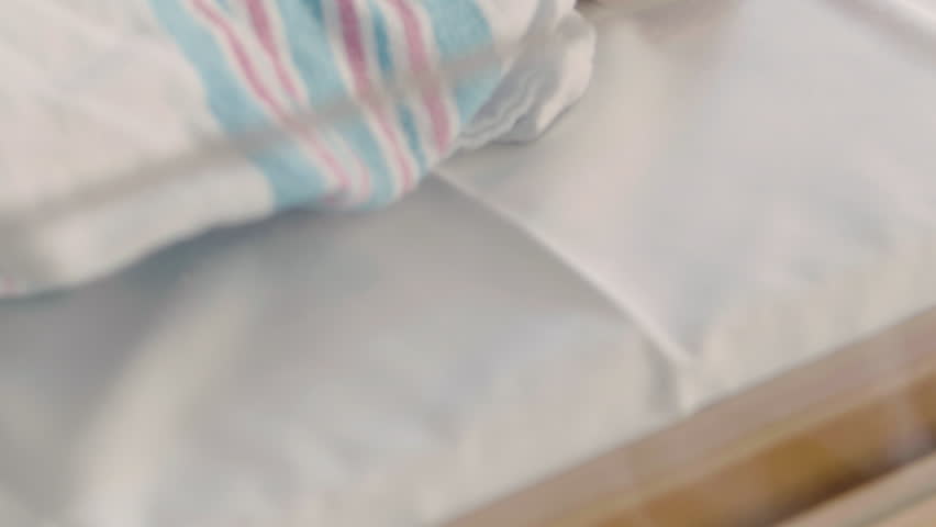 Close Up of Hospital Bed with Dreaming Baby Sticking Tongue Out