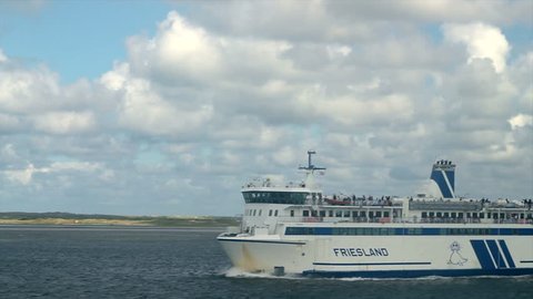 TERSCHELLING - AUGUST 19: Passenger ferry 'Vlieland' passing on the Waddensea on August 19, 2011 in the Netherlands. Island of Terschelling in the background.