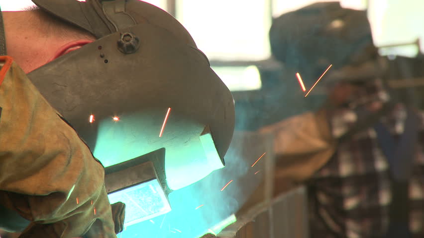 Man with mask welds with blowtorch