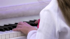 Piano player / Piano keyboard / Piano hands. Young pianist playing on a white piano. Hands and keyboard close-up. (av20163c)