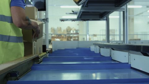 Parcels are Moving on Belt Conveyor at Post Sorting Office. Box POV.  Shot on RED Cinema Camera in 4K (UHD).