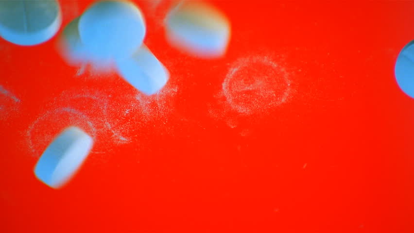 Blue tablets dropping on surface