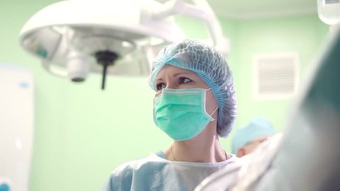 Doctor performs endoscopic surgery removing a brain tumor.