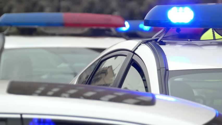 Police cars with lights flashing during a patrol  the city streets. Close up