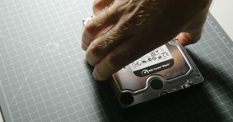 PARIS, FRANCE - CIRCA 2016: Man comparing HDD Hard Disk Drive with small SanDisk SSD Solid State Drive before computer upgrade