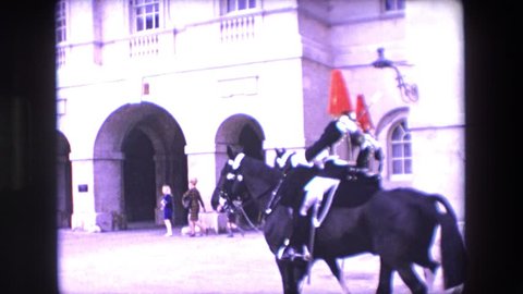 LONDON ENGLAND 1967: men horses riding towards castle red cap black horses people standing