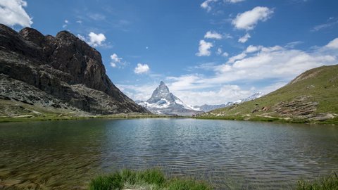 timelapse of the amazing matterhorn and surrounding mountains and lake in the Swiss Alps with fantastic cloud formations