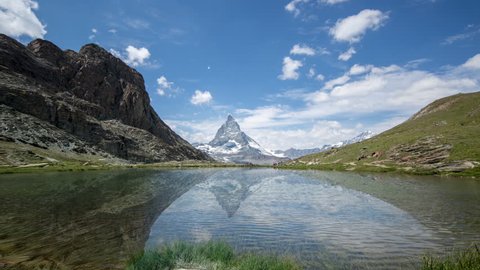 timelapse of the amazing matterhorn and surrounding mountains and lake in the Swiss Alps with fantastic cloud formations