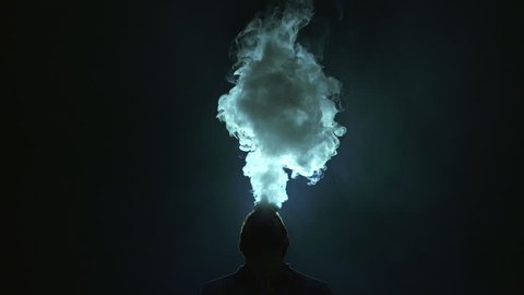 The man smoke electronic cigarette on the dark background