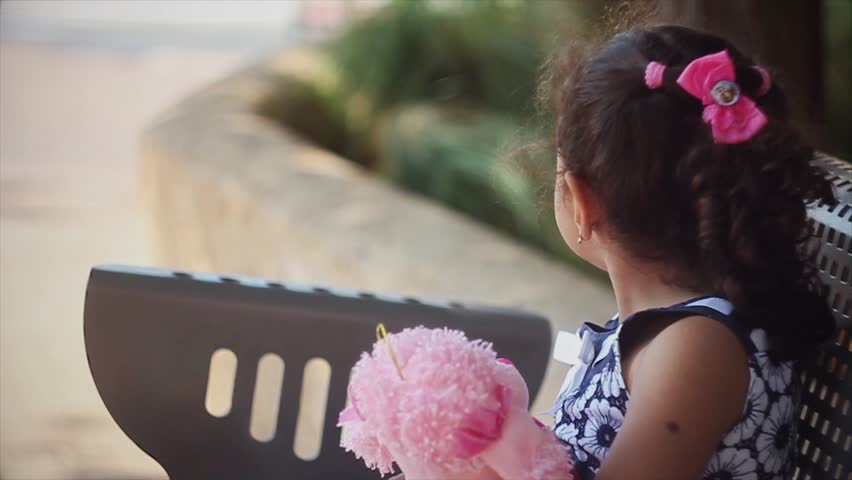 Little girl looks at the outside. Over the shoulder 